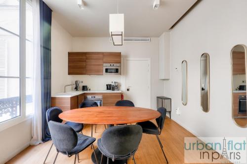 une cuisine avec une table et des chaises dans une pièce dans l'établissement Urban Flat 110 - Luxury 3BDR Flat near Opera Paris, à Paris