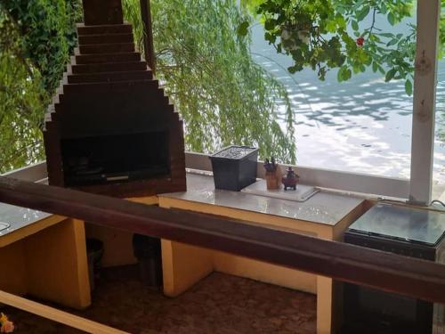 a television sitting on a table with a view of the water at Casa Golful Mraconiei Eselnita in Eşelniţa