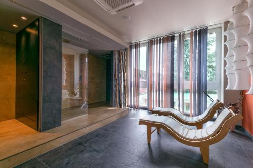 a living room with a bench and a large window at Admiral Park Hotel by Falco D'Oro Hotels in Zola Predosa