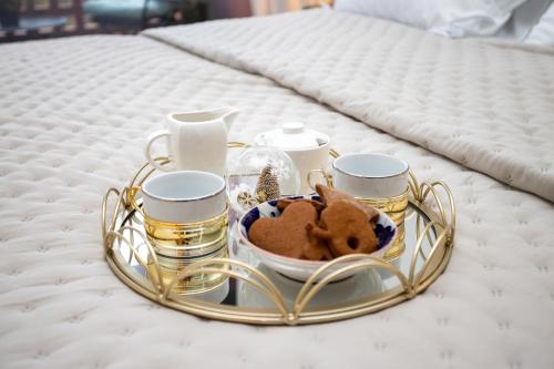 a tray with cookies and cups on a bed at Old Town Fabulous view apartment in Tallinn