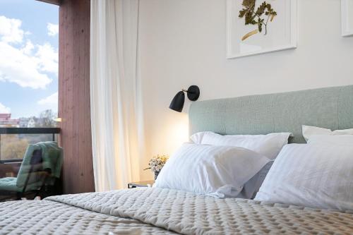 a bedroom with a bed with white pillows and a window at Old Town Fabulous view apartment in Tallinn