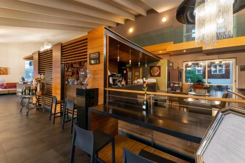 a bar in a restaurant with a counter and chairs at Admiral Park Hotel in Zola Predosa