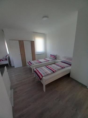 two beds sitting in a room with wooden floors at Apartmani Trifunovic in Banja Koviljača