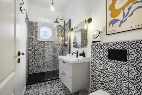 uma casa de banho em preto e branco com um lavatório e um espelho em WHome Premium Alfama 2-BR Great for Remote Workers & Digital Nomads em Lisboa