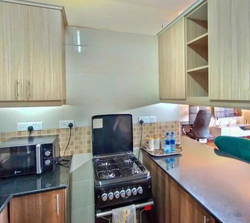 a kitchen with a stove and a microwave at The place rich in Nairobi