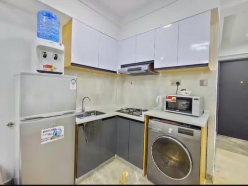 a kitchen with a refrigerator and a washing machine at The place rich in Nairobi