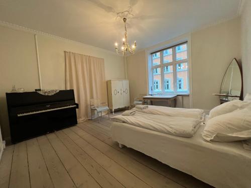 コペンハーゲンにあるOuthentic Apartmentのベッドルーム(ベッド1台、ピアノ付)
