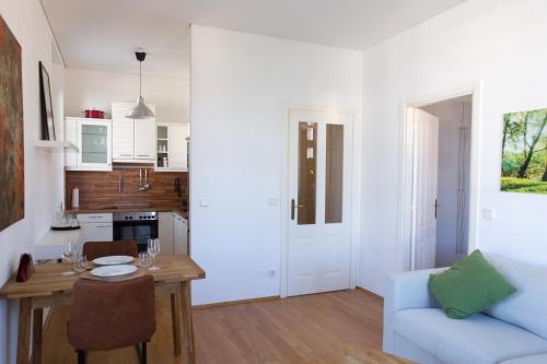 uma cozinha e sala de estar com uma mesa e um sofá em Pleasant City Apartment em Graz