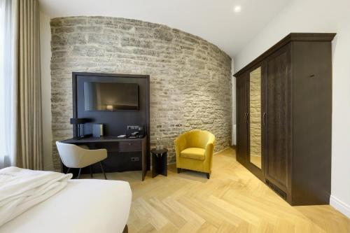 a bedroom with a brick wall and a bed and a desk at Nunne Boutique Hotel in Tallinn