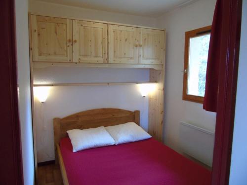 - une petite chambre avec un lit et des placards en bois dans l'établissement Charmant 2 pièces à Valfréjus, balcon ouest, proche télésièges et commerces, idéal 4 personnes - FR-1-561-6, à Valfréjus