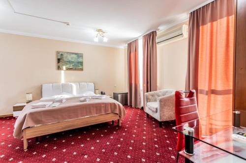 a hotel room with a bed and a chair at Star Rent Hotel in Chişinău