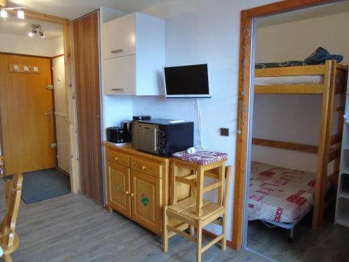 a room with a desk with a microwave and a bunk bed at Studio Valfréjus, 1 pièce, 4 personnes - FR-1-561-8 in Valfréjus
