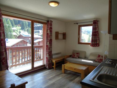 un salon avec un canapé et une grande fenêtre dans l'établissement Appartement cozy 6 pers., 50m écoles ski, WIFI, parking, balcon - FR-1-561-18, à Valfréjus