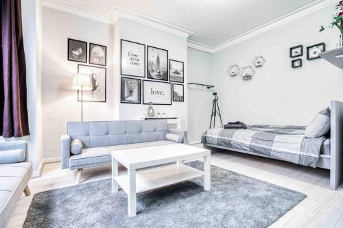 a white living room with a couch and a bed at Cheerful Flat In Moseley With Free Parking in Birmingham