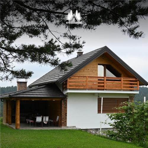 a house with a porch with chairs and tables at Vikendica Stevanovic in Doboj
