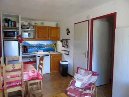 Il comprend une cuisine équipée d'un réfrigérateur, d'une table et de chaises. dans l'établissement Appartement Valfréjus, 3 pièces, 6 personnes - FR-1-561-28, à Valfréjus