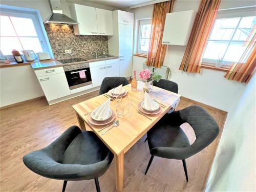 a kitchen with a wooden table with four chairs at BIG Apartment for YOUR DREAM Vacation Bavarian Forest + NETFLIX in Schöfweg