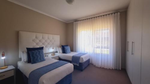 a hotel room with two beds and a window at 2 On Lismore Guesthouse in Tokai