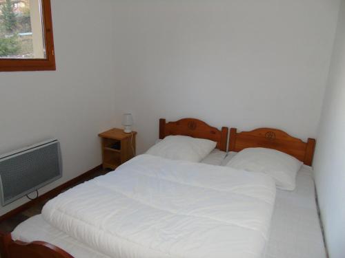 une chambre avec un lit blanc et une télévision dans l'établissement Appartement cosy 2 P+Cabine pour 6, proche pistes et commerces, vue Parc Vanoise - FR-1-561-48, à Valfréjus