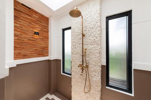 a walk in shower in a bathroom with windows at The Lavana Sasandu Gunung Salak Bogor 
