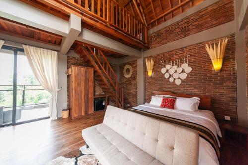 a bedroom with a large bed and a brick wall at The Lavana Sasandu Gunung Salak Bogor 