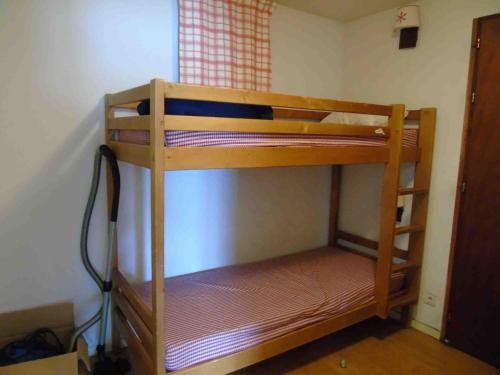 a wooden bunk bed in a room with a window at Appartement Valfréjus, 3 pièces, 8 personnes - FR-1-561-59 in Valfréjus