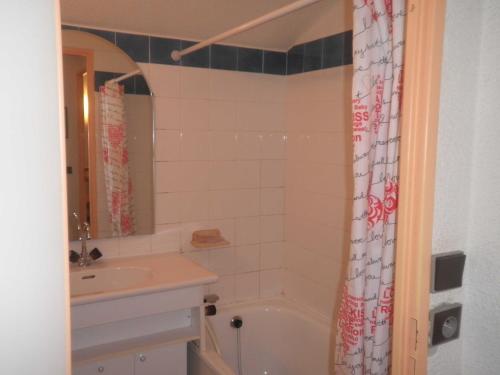 La salle de bains est pourvue d'un lavabo, d'une baignoire et d'un rideau de douche. dans l'établissement Studio Valfréjus, 1 pièce, 4 personnes - FR-1-561-63, à Valfréjus