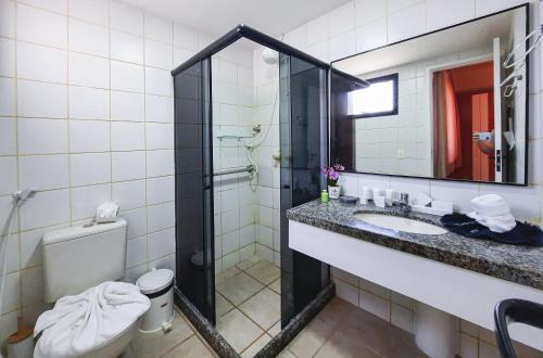 een badkamer met een douche, een wastafel en een toilet bij Aquaville Resort Pé na Areia 3 suítes 7 Pessoas in Aquiraz