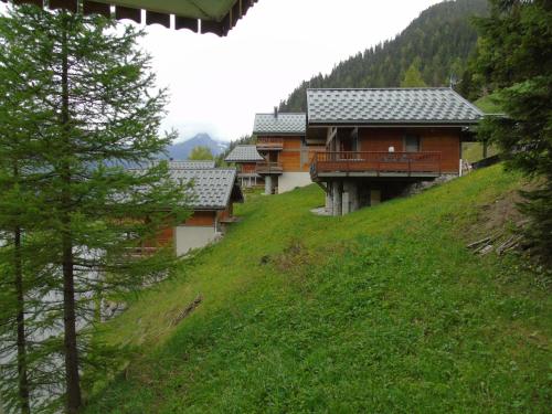 un groupe de maisons sur une colline avec des arbres dans l'établissement Appartement cosy 2 pièces avec terrasse, proche télésièges et commerces, idéal pour 6 personnes! - FR-1-561-78, à Valfréjus