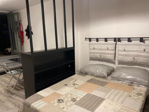 a bed in a room with a black and white bed frame at Studio AIX LES BAINS in Aix-les-Bains