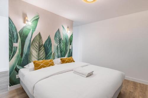- une chambre avec un lit blanc orné d'une fresque murale représentant des feuilles dans l'établissement Sentier Réaumur - Beautiful Apartment III, à Paris