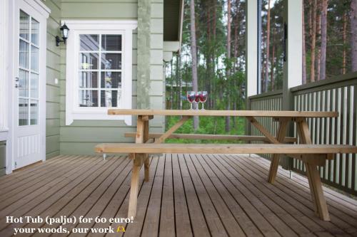 a wooden bench on a porch with a table at SResort Saunas - hot tub, palju in Imatra