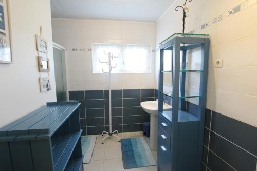 Łazienka z niebieską szafką i umywalką w obiekcie Le gite des marais w mieście Auvers