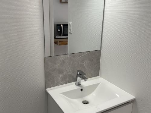 a white sink in a bathroom with a mirror at Studio Aix-les-Bains, 1 pièce, 2 personnes - FR-1-617-25 in Aix-les-Bains
