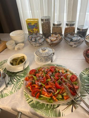 a table with a salad in a bowl on a table at Hotel Pacific in Timişoara