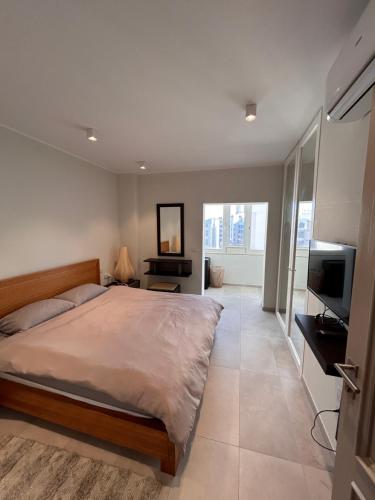 a bedroom with a bed and a flat screen tv at Luxury Private Room - TV in Paceville