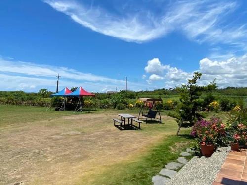 a picnic table and a gazebo in a field at Tamowan in Donghe