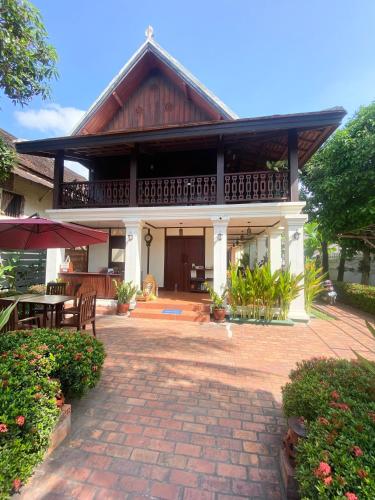 a house with a patio and a building at Luang Prabang Residence & Travel in Luang Prabang