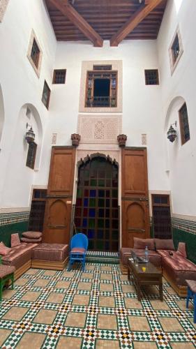 een grote kamer met banken en tafels in een gebouw bij Riad Alfredo in Fès