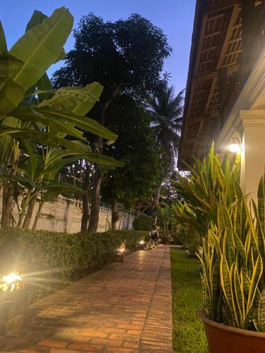 a cobblestone walkway in front of a building at night at Luang Prabang Residence & Travel in Luang Prabang