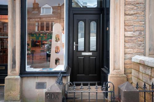 a black door with a snowboard in a store window at Albert Road Apartments Room 1 in Colne