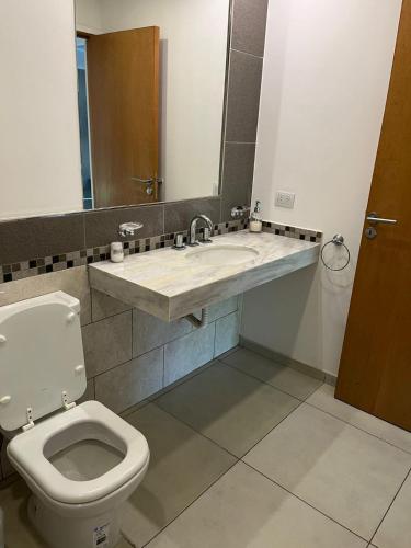 a bathroom with a toilet and a sink at Departamento de 1 dormitorio in Venado Tuerto