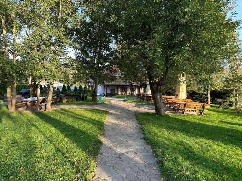 einen Weg in einem Park mit Bänken und Bäumen in der Unterkunft Restauracja i Hotel Oberża Wilczy Głód in Krzyszkowice