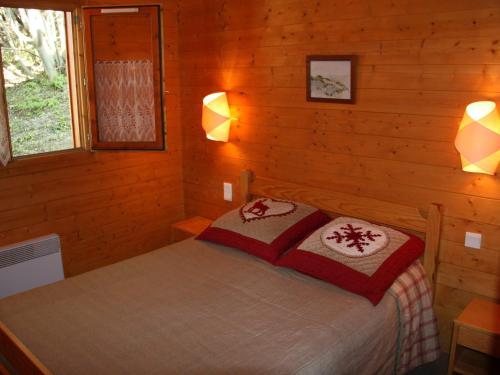 une chambre avec un lit dans une cabane en rondins dans l'établissement Chalet à Montalbert: 3 Chambres, Mezzanine, Cheminée, Cuisine Équipée, Parking - FR-1-755-7, à Aime La Plagne