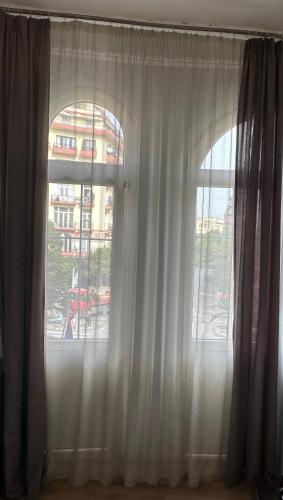 a window with white curtains in front of a building at Hotel Ilisia in Thessaloniki