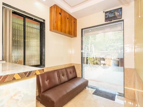 a leather couch in a kitchen with a glass window at Hotel BKC Fortune in Mumbai