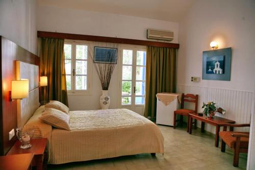 a bedroom with a bed and a room with a table at AEGEON in Kalloni