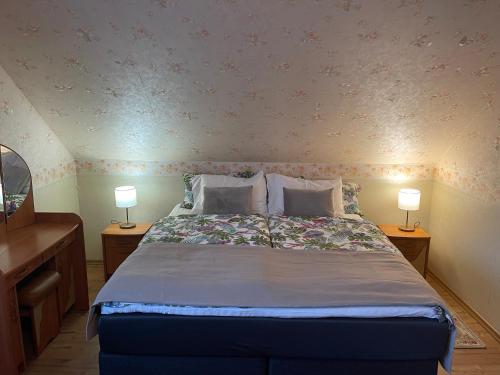 a bedroom with a bed with two lamps on two tables at Lana House in Pärnu