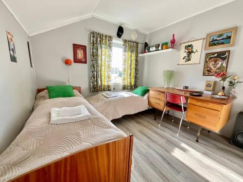 een slaapkamer met 2 bedden en een bureau bij Flakstad Beach Panorama Lofoten in Ramberg