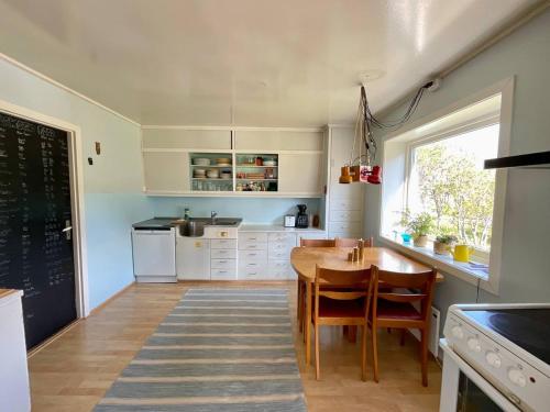 a kitchen with a wooden table and a dining room at Flakstad Beach Panorama Lofoten in Ramberg